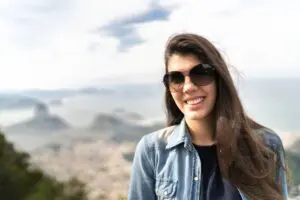 Woman smiling with sunglasses outdoors