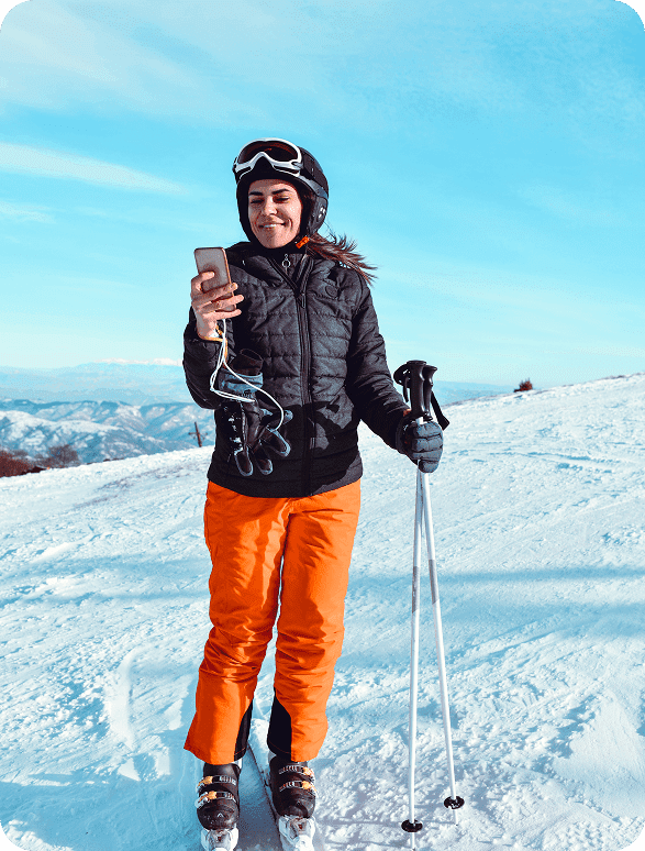 Skier smiling while on phone