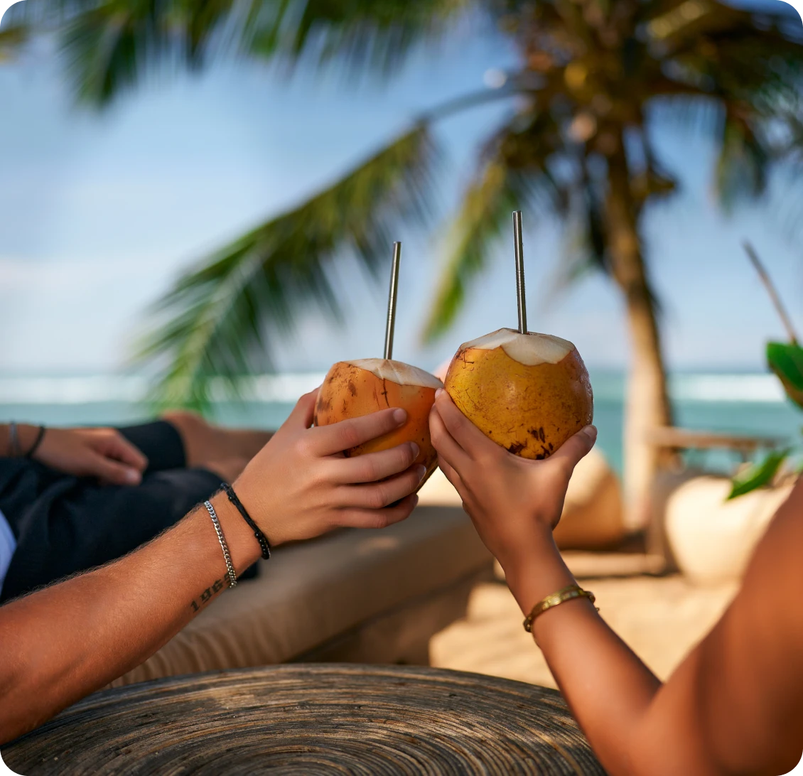 Enjoying fresh coconuts under palm trees